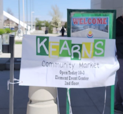 A sign advertising the Kearns Community Market event displayed outside the Element Event Center
