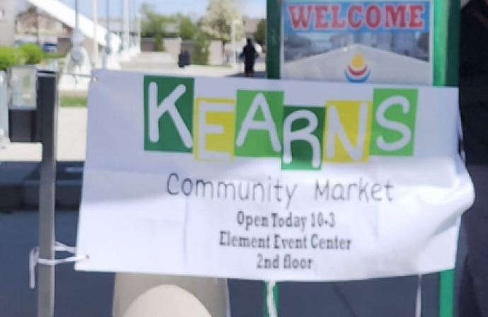A sign advertising the Kearns Community Market event displayed outside the Element Event Center